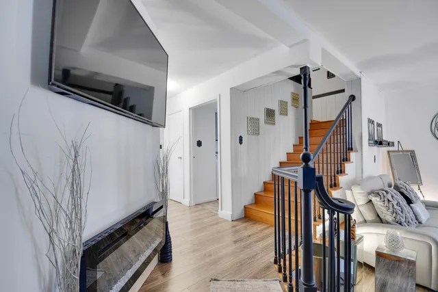 a view of a livingroom with wooden floor and staircase