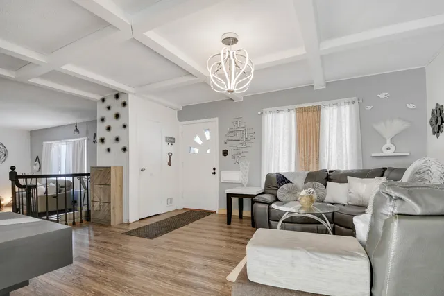 a living room with furniture and a chandelier