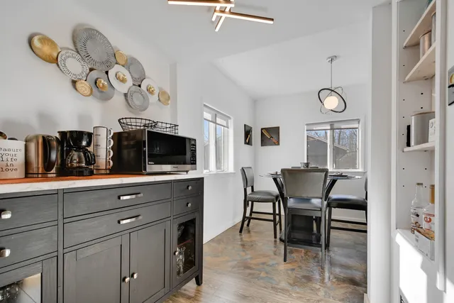 a view of dining room and kitchen with furniture and a clock