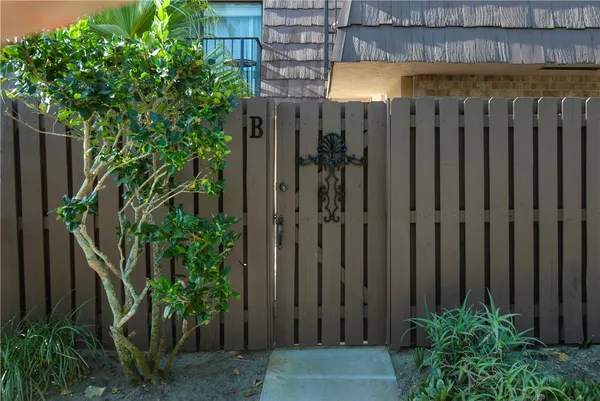 a view of a backyard with potted plants and wooden fence