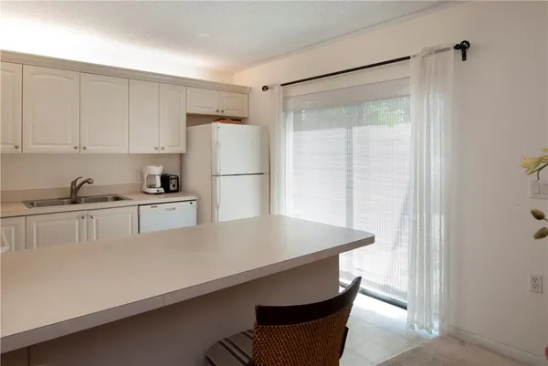 a kitchen with a refrigerator a stove a sink and white cabinets