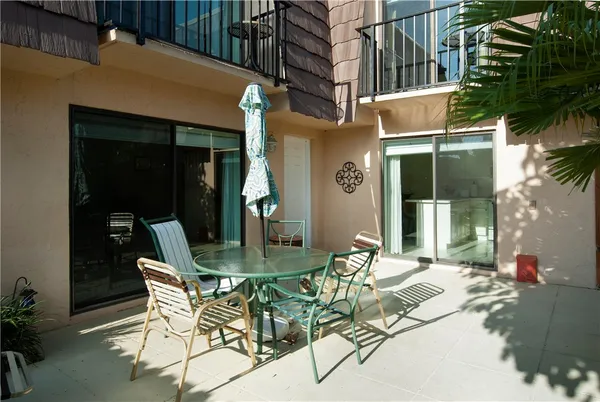 a view of a patio with table and chairs and potted plants