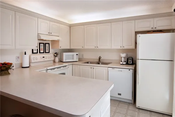 a kitchen with white cabinets and white appliances