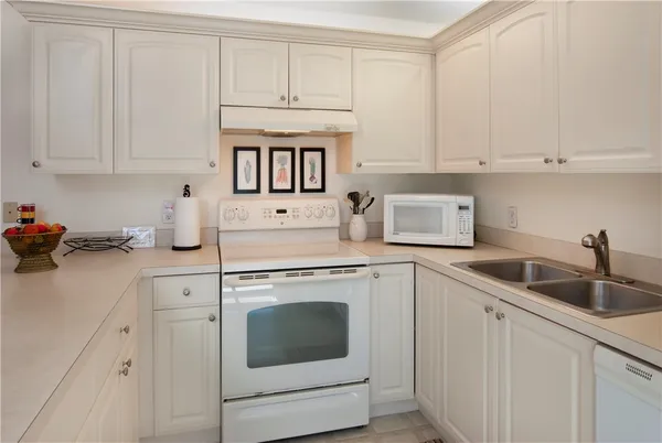 a kitchen with white cabinets and white appliances