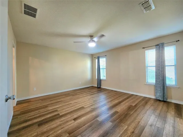 wooden floor in an empty room with a window