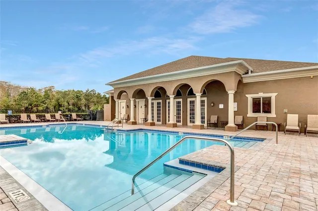 a view of a house with swimming pool and sitting area