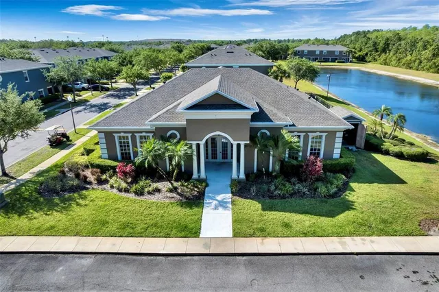 an aerial view of a house with a yard and lake view