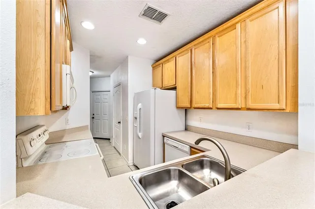 a kitchen with a sink a refrigerator and cabinets