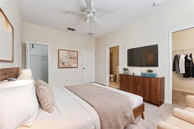 a bedroom with a large bed and a flat screen tv