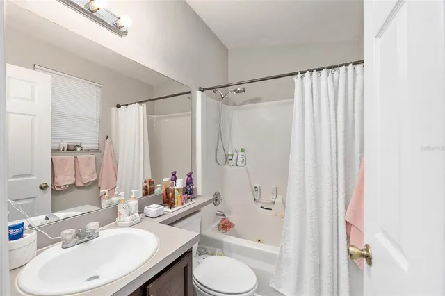 a bathroom with a sink toilet double vanity and shower