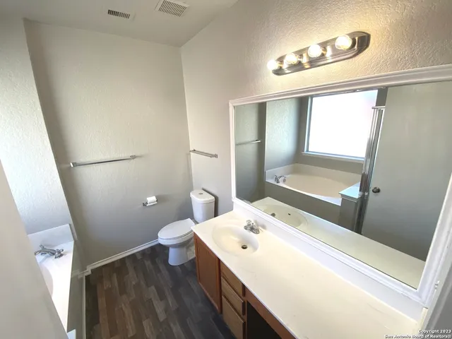 a bathroom with a tub sink and mirror