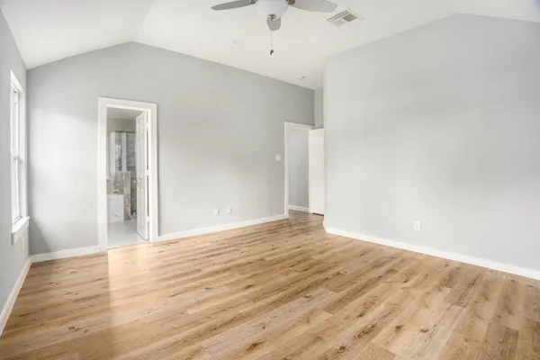 a view of an empty room with wooden floor