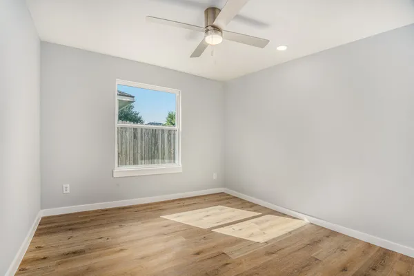 an empty room with a window and wooden floor