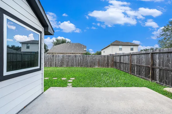 a view of backyard with table and chairs and wooden fence