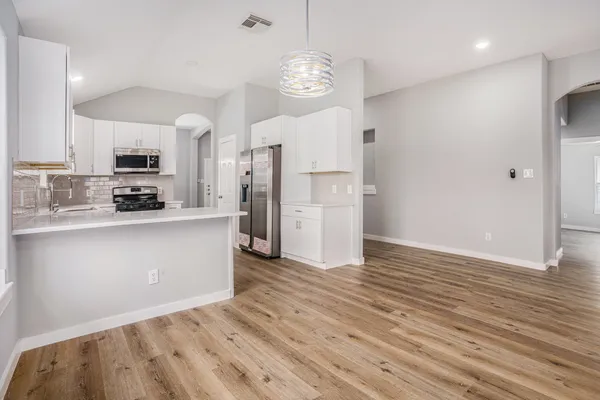 a kitchen with stainless steel appliances a refrigerator sink and cabinets