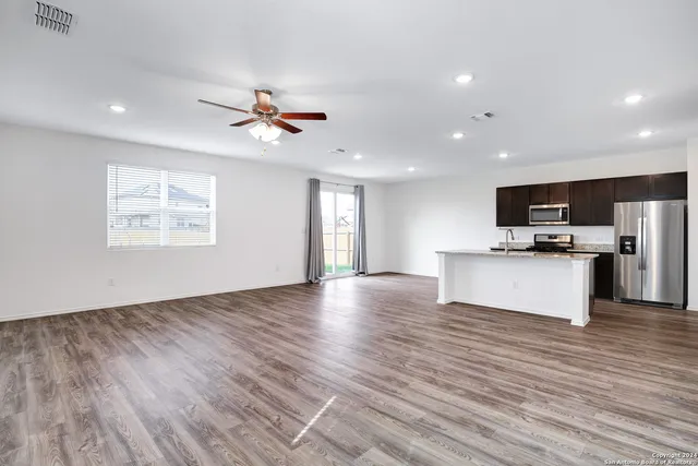 a view of kitchen with granite countertop cabinets and refrigerator