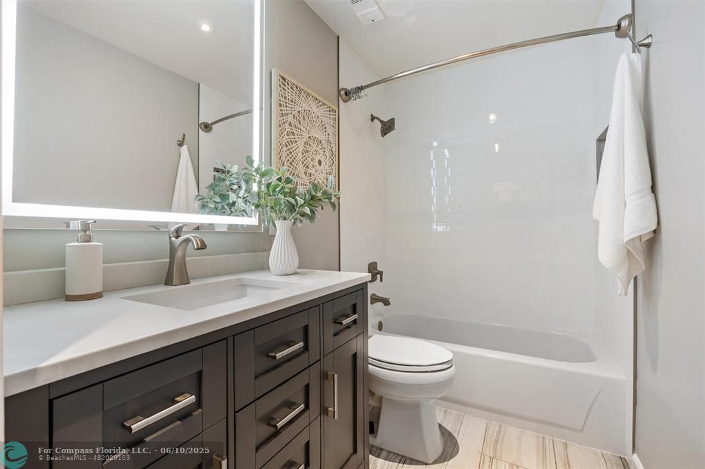 9804 Northwest 1st Court, Unit 9804 Plantation, FL 33324 - Photo 16 of 25 a bathroom with a granite countertop sink a toilet a mirror and shower