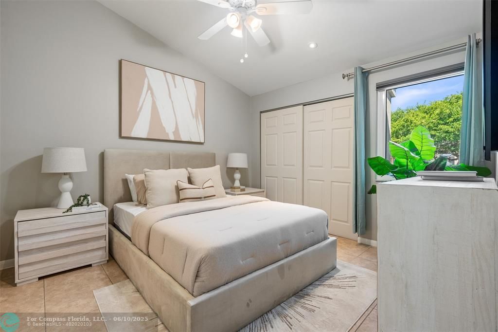 9804 Northwest 1st Court, Unit 9804 Plantation, FL 33324 - Photo 17 of 25 a bedroom with a large bed and a chandelier