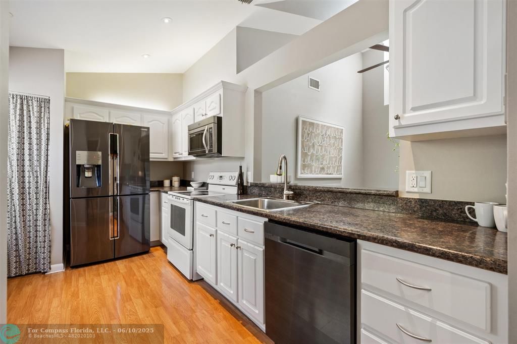 9804 Northwest 1st Court, Unit 9804 Plantation, FL 33324 - Photo 4 of 25 a kitchen with stainless steel appliances granite countertop a sink stove and refrigerator