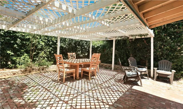 a view of a patio with a dining table and chairs with wooden floor and fence