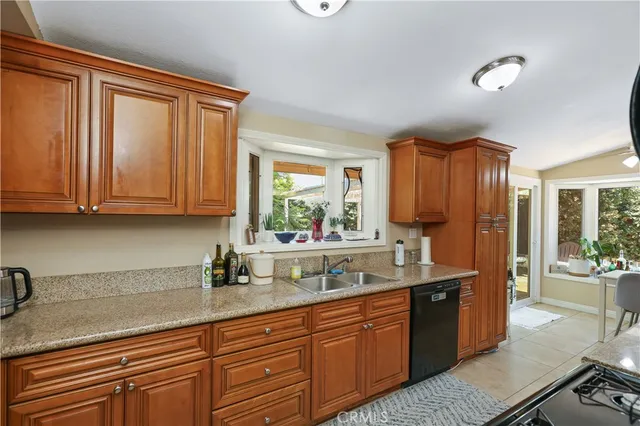 a kitchen with stainless steel appliances granite countertop a sink a stove and cabinets