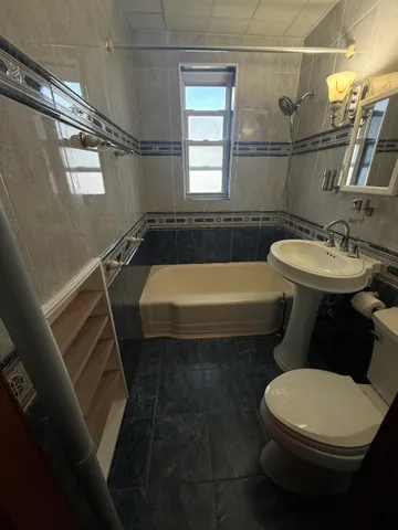 a bathroom with a sink a toilet a mirror and bathtub