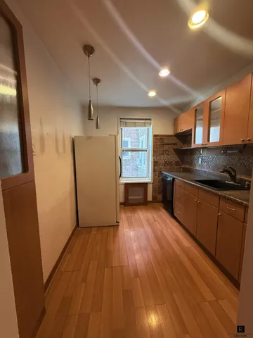a kitchen with granite countertop a sink and wooden floor