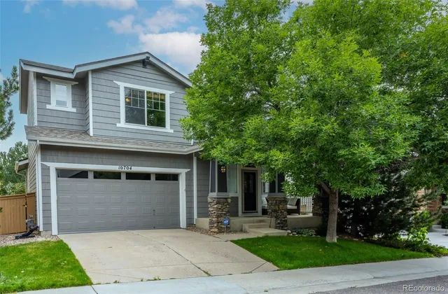 a front view of a house with yard and trees