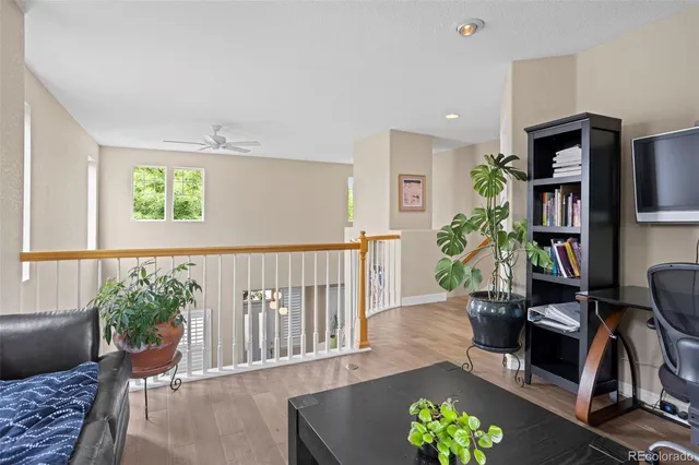 a living room with furniture floor to ceiling window and a potted plant