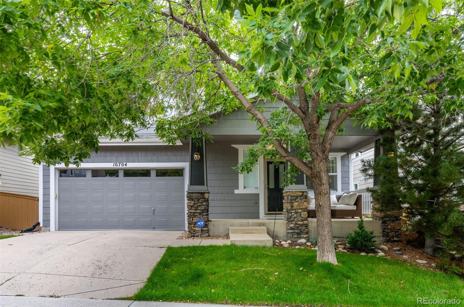 10704 Riverbrook Circle Highlands Ranch, CO 80126 - Photo 3 of 40 a front view of a house with a garden and trees