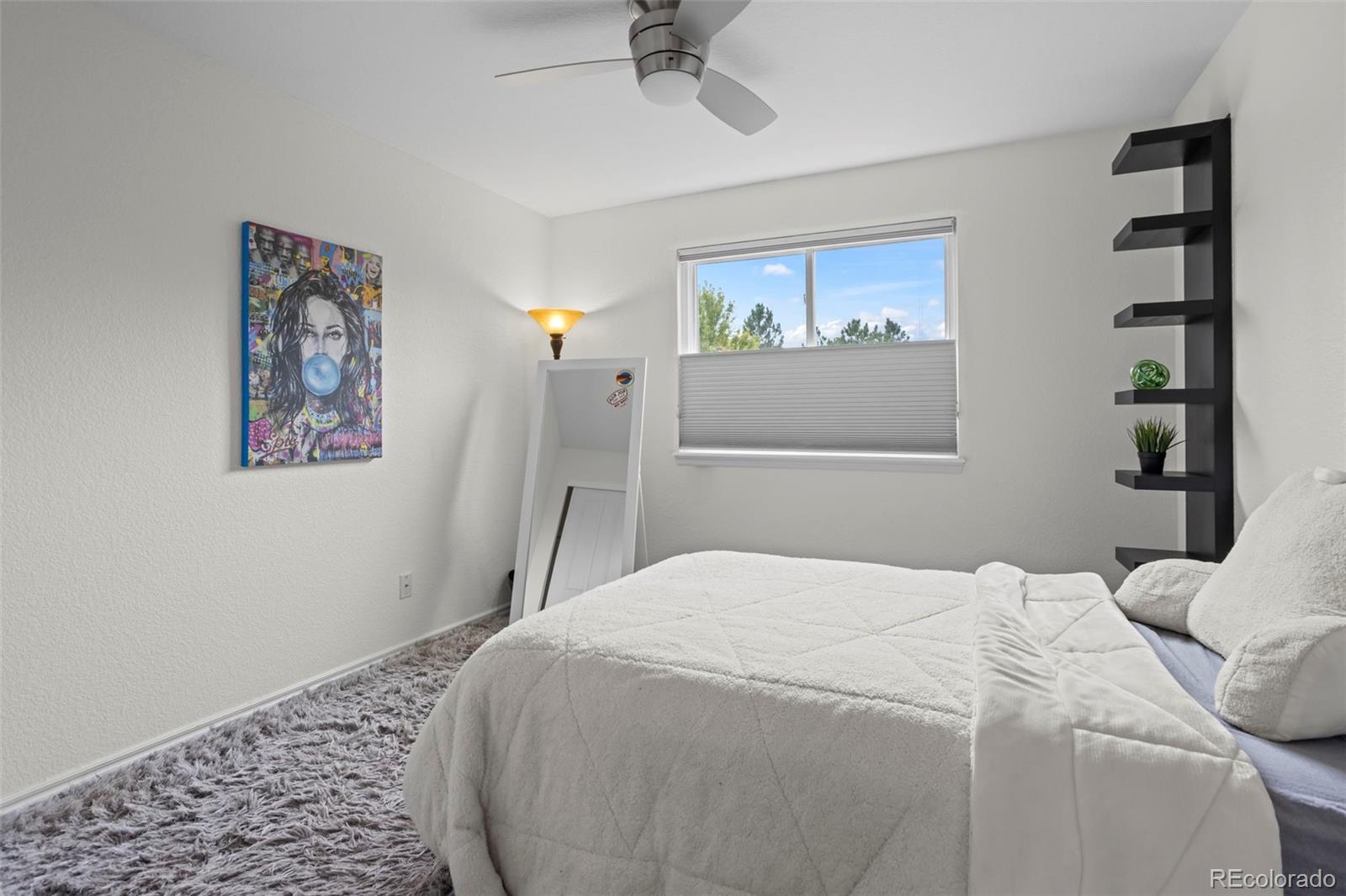 10704 Riverbrook Circle Highlands Ranch, CO 80126 - Photo 33 of 40 a bedroom with a bed and a painting on the wall
