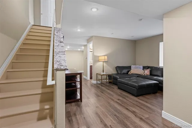 a living room with furniture and wooden floor