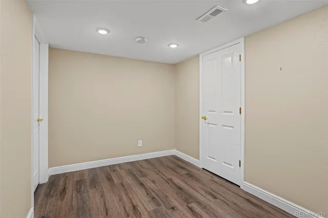a view of an empty room with wooden floor
