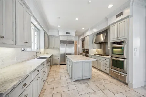 a large kitchen with stainless steel appliances granite countertop a stove sink and cabinets