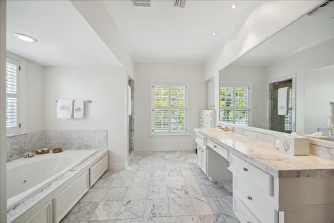 a spacious bathroom with a granite countertop tub sink and mirror
