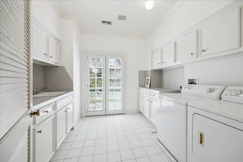 a large white kitchen with cabinets