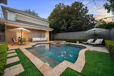a view of a swimming pool with chairs and a table
