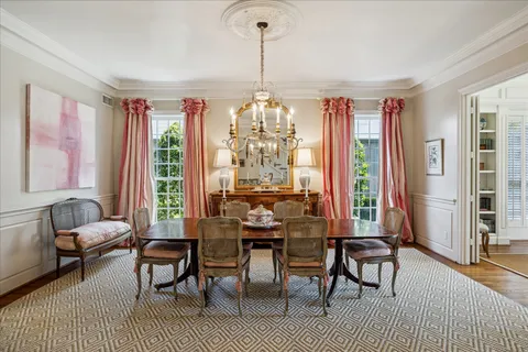 a dining room with furniture a chandelier and wooden floor