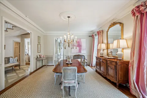 a dining room with furniture a chandelier and wooden floor
