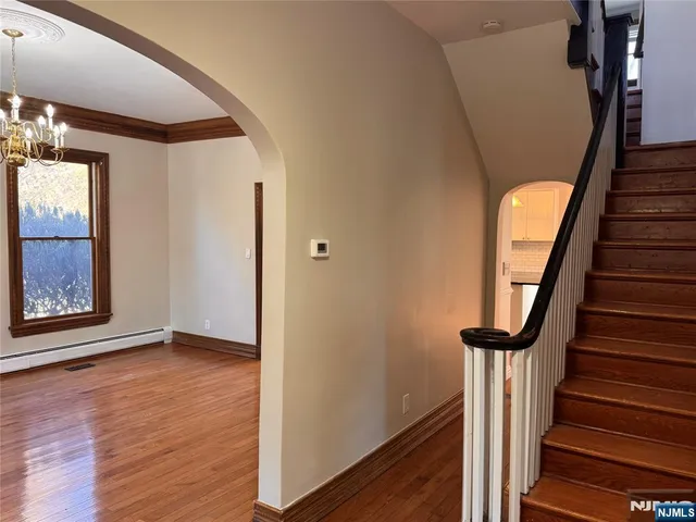 a view of an entryway with wooden floor and stairs