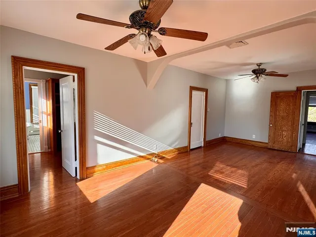 a view of empty room with wooden floor