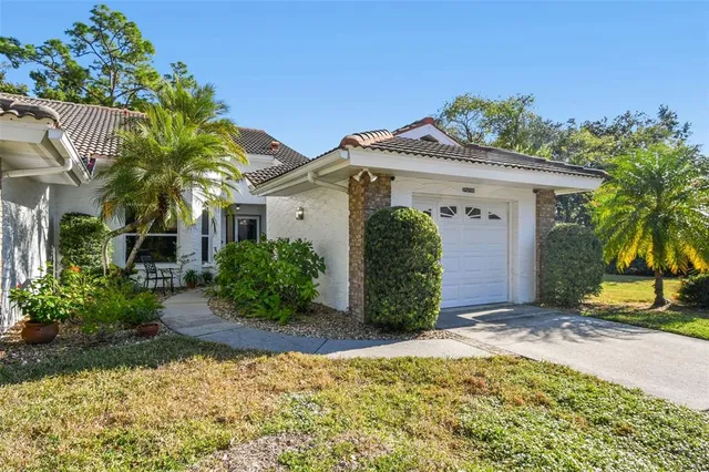 a view of a house with a small yard and potted plants
