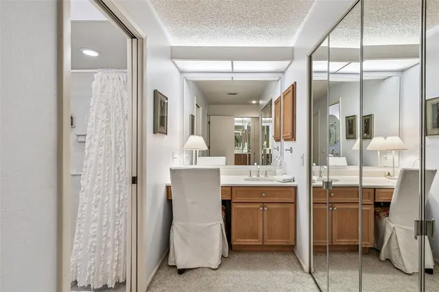 a room with chandelier fan and kitchen view