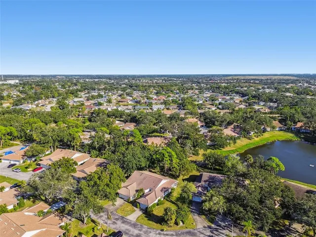 an aerial view of residential house with outdoor space and trees all around