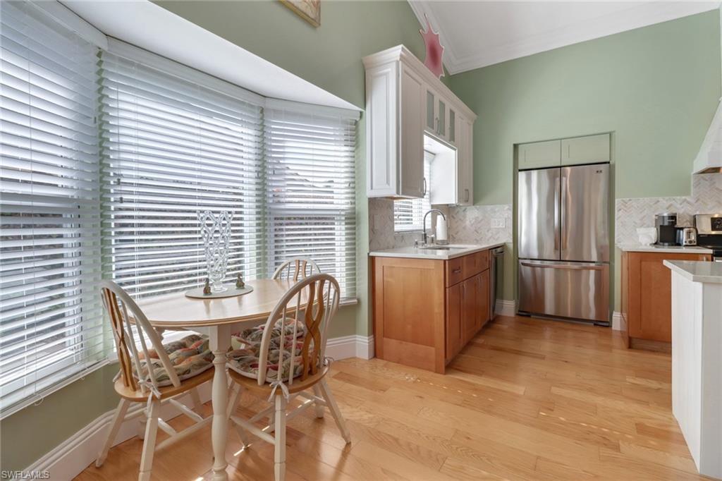 310 Fox Den Circle Naples, FL 34104 - Photo 11 of 46 a kitchen with stainless steel appliances wooden floors and white cabinets