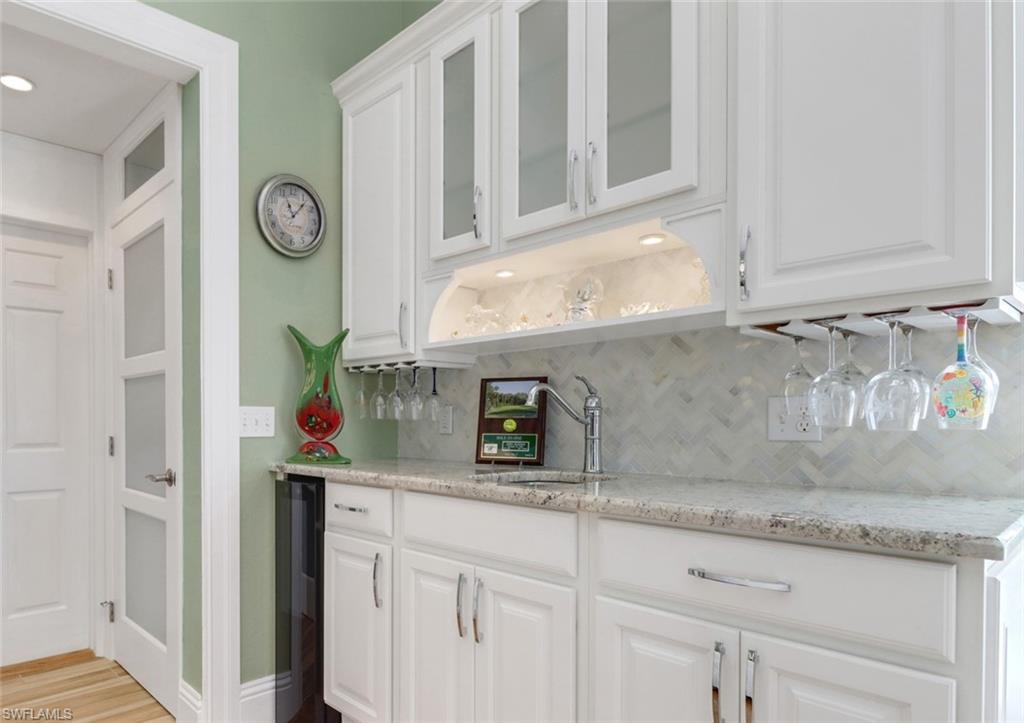 310 Fox Den Circle Naples, FL 34104 - Photo 14 of 46 a kitchen with white cabinets and a sink