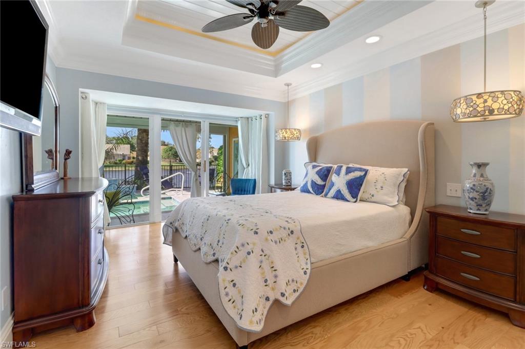 310 Fox Den Circle Naples, FL 34104 - Photo 16 of 46 a bedroom with a bed and a chandelier