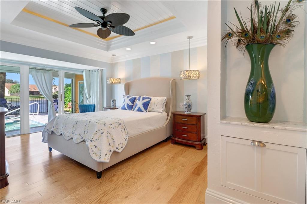 310 Fox Den Circle Naples, FL 34104 - Photo 17 of 46 a bed room with a bed and a chandelier
