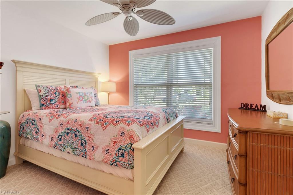310 Fox Den Circle Naples, FL 34104 - Photo 22 of 46 a bedroom with a large bed and a chandelier