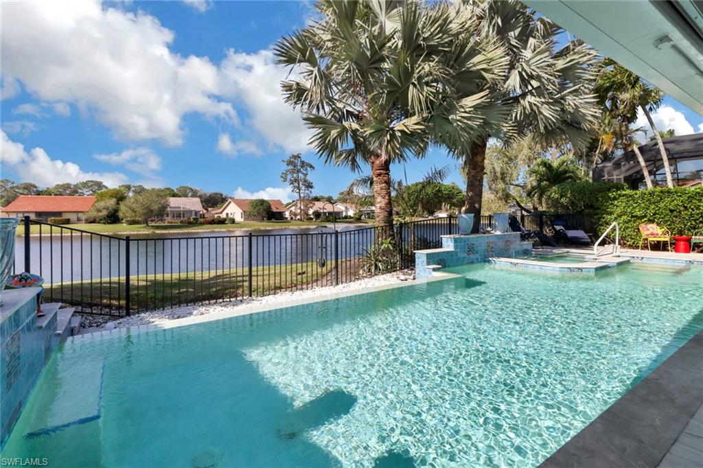 310 Fox Den Circle Naples, FL 34104 - Photo 27 of 46 a view of a yard and swimming pool with wooden fence